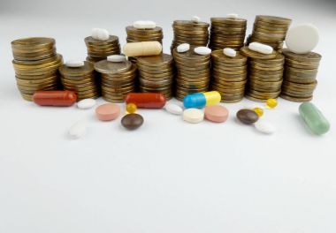 Beyaz arka planda izole edilmiş haplar ve madeni paralar