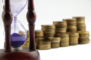 Kum saati ve beyaz arka plan üzerinde izole paralar