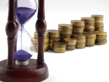 Kum saati ve beyaz arka plan üzerinde izole paralar