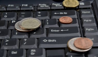 Beyaz arka plan üzerinde izole bir dizüstü bilgisayar üzerinde paralar