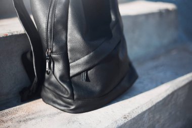 Şehir merdivenlerinde siyah sırt çantasının yakın çekimi.