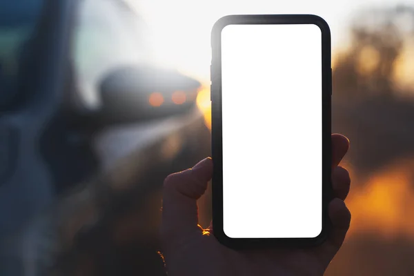 Закрытие Смартфона Макетом Мужской Руке Фоне Размытого Автомобиля Заката — стоковое фото