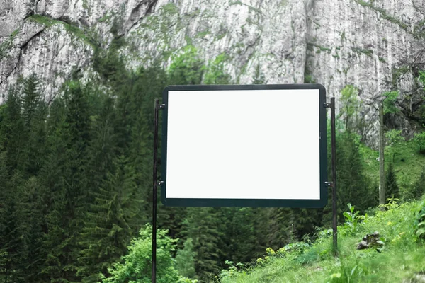 山の緑の森の中で空の白いモックアップと広告看板 — ストック写真