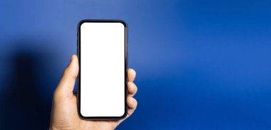 Hayalet mavi arka planda izole edilmiş beyaz modelli akıllı telefonlu erkek eli yakın plan..