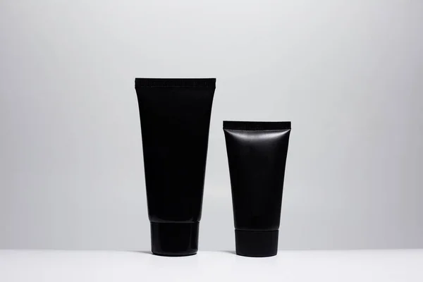 Close Van Twee Zwarte Crème Buizen Geïsoleerd Witte Achtergrond — Stockfoto