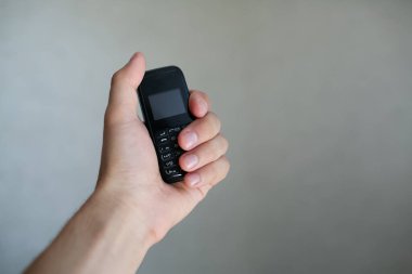 Eski siyah cep telefonunu tutan adamın yakın çekimi..