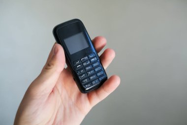 Eski siyah cep telefonunu tutan adamın yakın çekimi..