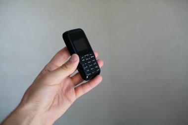 Eski siyah cep telefonunu tutan adamın yakın çekimi..