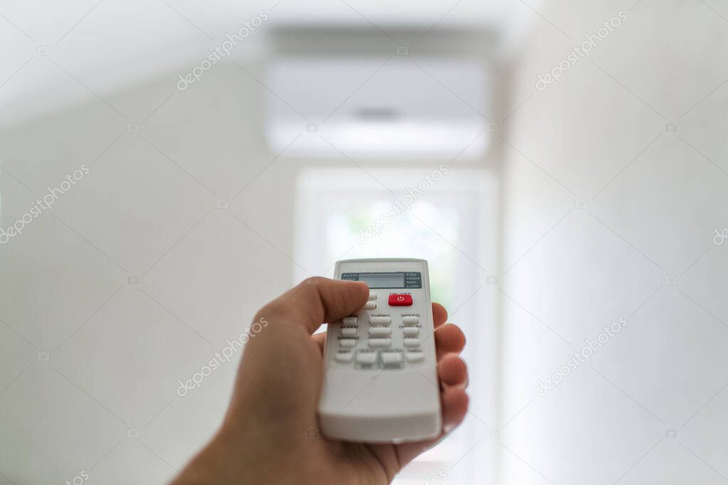 Close-up of remote control for conditioner in man hand.