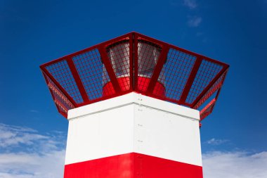 Mavi gökyüzünün arka planındaki deniz fenerinin yakın görüntüsü.