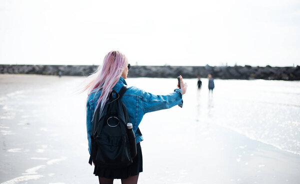 Close up of young girl taking selfie on the beach.