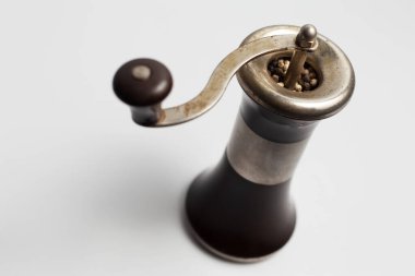 Beyaz arka planda antik biber değirmeni.