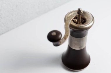 Beyaz arka planda antik biber değirmeni.