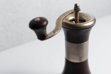 Beyaz arka planda antik biber değirmeni.