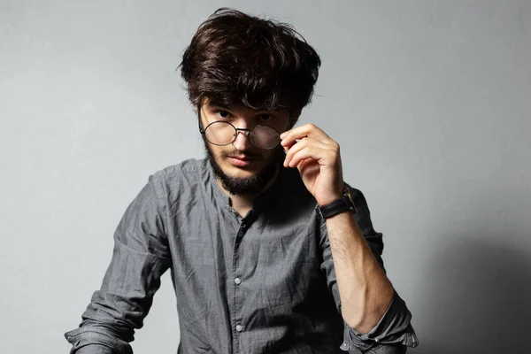 Portrait Young Bearded Guy Disheveled Hair Touching His Glasses Looking Stock Image