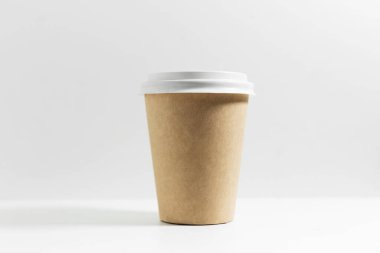 Kahve için tek kullanımlık kağıt bardağı yakın plan, beyaz kapaklı, beyaz arka planda izole edilmiş..