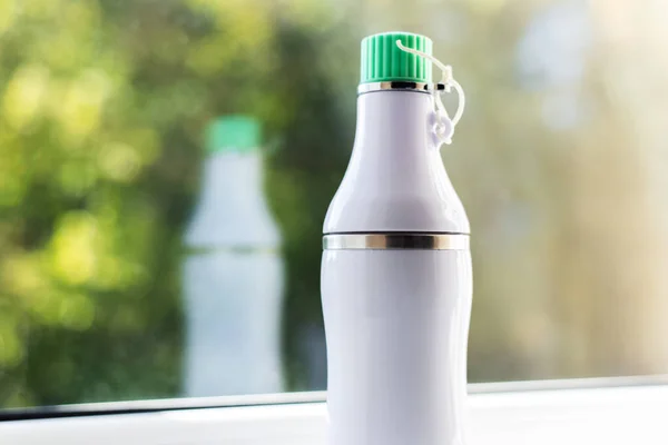 Close-up of white steel thermo bottle for water.