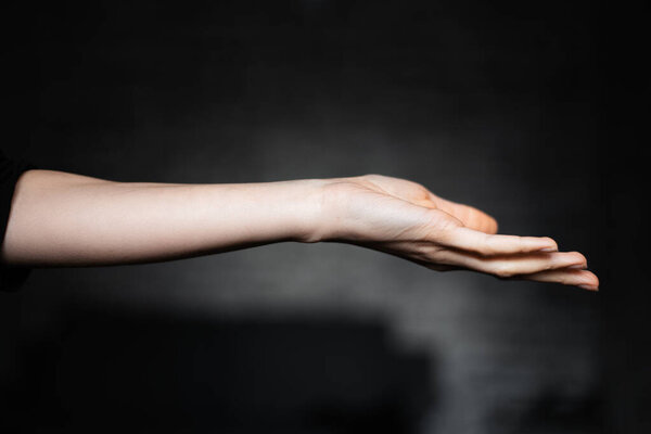 Female hand on black background.
