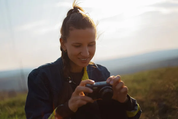 日没を背景にデジタル写真カメラを持つ少女の肖像 — ストック写真