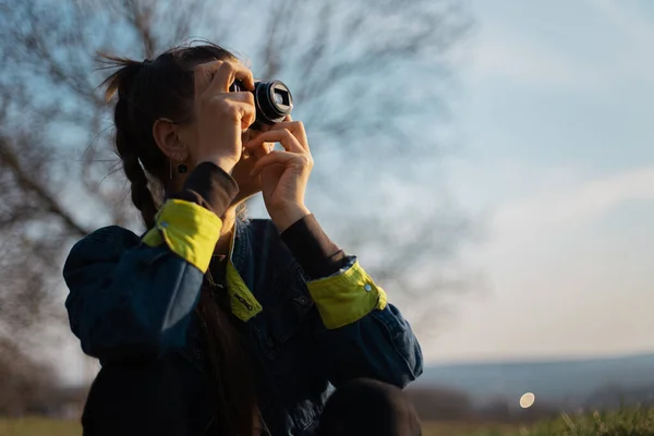 Retrato Menina Segurando Câmera Fotográfica Digital Fundo Pôr Sol — Fotografia de Stock