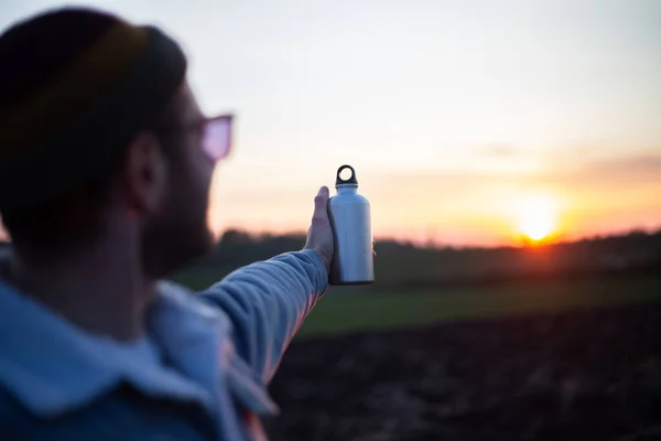 Ruka Muže Držícího Hliníkovou Láhev Vodu Pozadí Západu Slunce — Stock fotografie