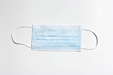 Tıbbi koruyucu grip maskesine yakın plan, mavi, beyaz arka plan.