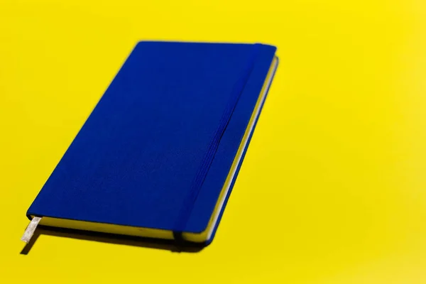 黄色の背景に青のノートブックのクローズアップ — ストック写真