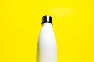 Yarısı yeniden kullanılabilir eko, su için çelik termos şişesi, beyaz renkli, sarı arka planda izole edilmiş..