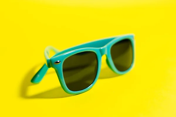 Nahaufnahme Einer Sonnenbrille Aus Cyan Auf Gelbem Hintergrund — Stockfoto
