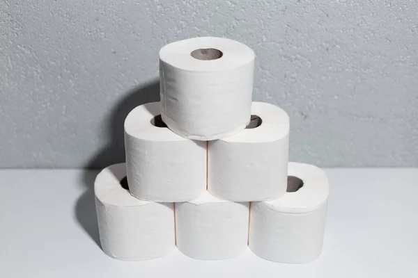 Крупный План Рулонов Туалетной Бумаги Белом Столе Фон Текстурированной Стены — стоковое фото