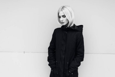 Açık havada parka ceket giyen düşünceli genç kızın siyah beyaz portresi..