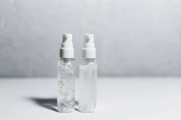 Крупный План Двух Переносных Пластиковых Бутылок Антисептическим Гелем Белом Столе — стоковое фото