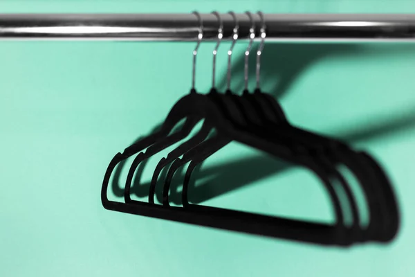 Close Van Kledingrek Met Zwarte Lege Hangers Achtergrond Van Aqua — Stockfoto