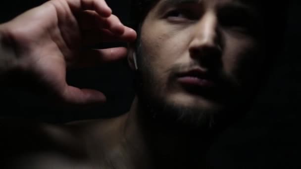 Dunkles Nahaufnahme Porträt Eines Jungen Mannes Mit Drahtlosen Kopfhörern Auf — Stockvideo