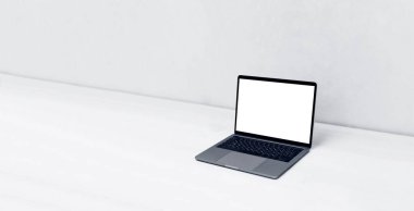 Dizüstü bilgisayarın minimalist fotoğrafı beyaz masa üzerinde kopyalama alanı ile birlikte..