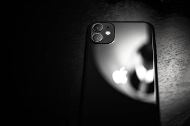 Moldova, Chisinau - 03.11.2019: Koyu ahşap masa üzerinde siyah iPhone 11 'e yakın plan.