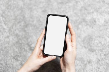 Arkaplanı gri renkte olan akıllı telefonlu kadınların yakın plan görüntüleri..