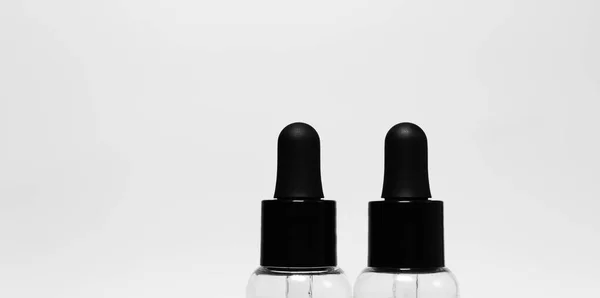 Close Van Twee Transparante Flessen Met Zwarte Pipetten Geïsoleerd Witte — Stockfoto