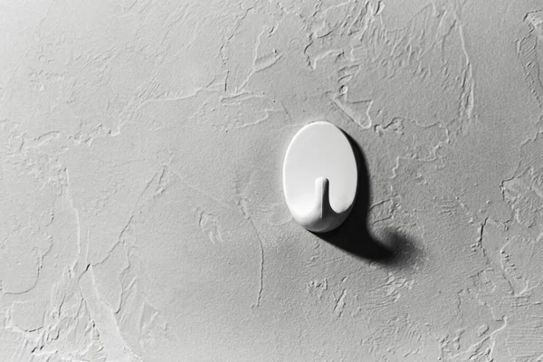 Giysilerin yakın plan kancası gri duvarın arka planında.