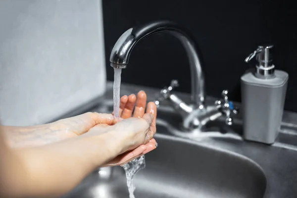 Close Van Handen Wassen Met Water Onder Kraan Naast Dispenserfles — Stockfoto