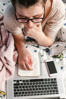  Evde dizüstü bilgisayarı olan genç bir anne. Ev rahatlığı. Dikkat ve dikkat. Evden çalışıyorum. Kadın işi..