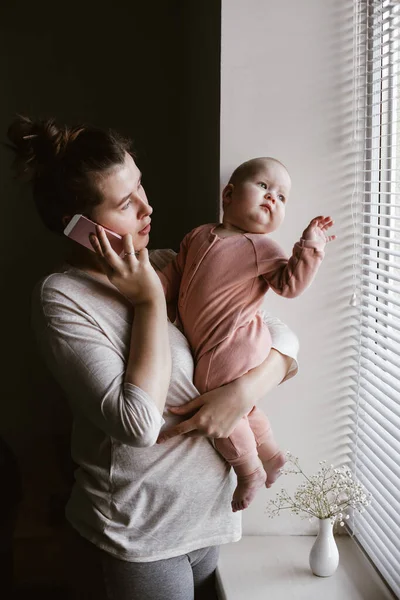 Femme Avec Bebe Parlant Au Telephone Et Regardant Par La Fenetre Travail A Domicile En Utilisant Technologie Stock Photo Femme Avec Bebe Parlant Au Telephone Et Regardant Par La Fenetre Travail A Domicile En Utilisant Technologie Stock Photo