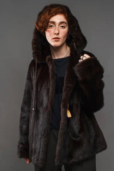 Menina em casaco de pele de inverno sobre fundo cinza — Fotografia de Stock