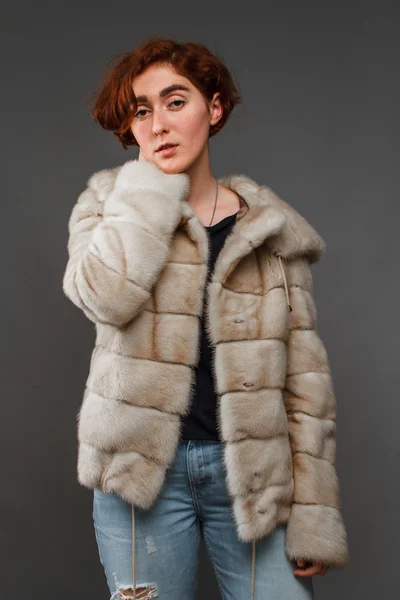 Chica en abrigo de piel de invierno sobre fondo gris — Foto de Stock
