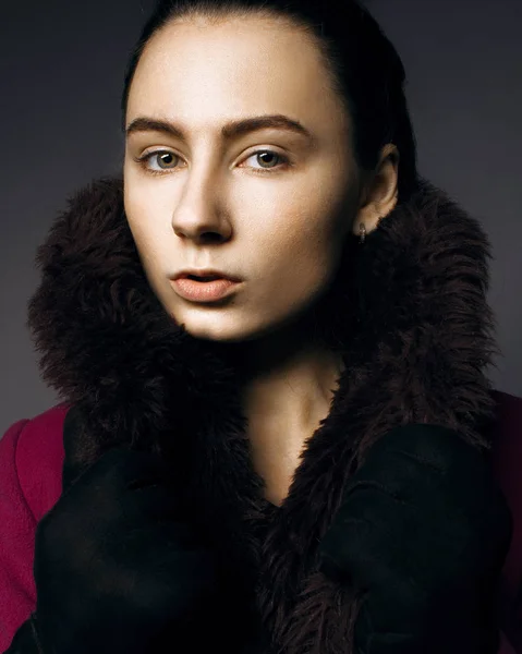 Retrato sério de uma menina de casaco de pele no estúdio — Fotografia de Stock