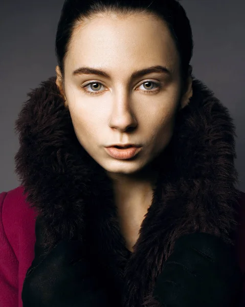 Retrato sério de uma menina de casaco de pele no estúdio — Fotografia de Stock
