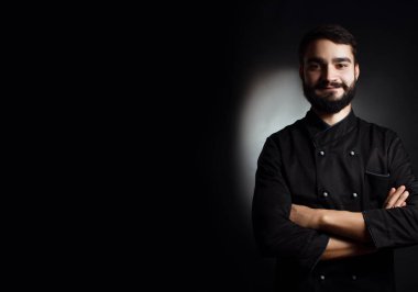 Siyah siyah bir arka plan üzerinde üniforma sakallı profesyonel şef
