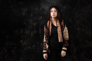Bir siyah arka plan dokulu duvar moda giysiler içinde güzel kız