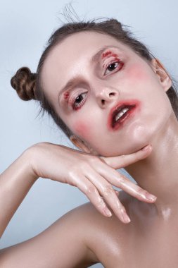 Duygusal olarak mavi bir arka plan üzerinde poz ıslak makyajlı kız