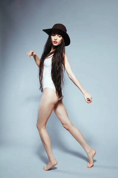Όμορφη κοπέλα με μακριά μαλλιά με λευκό κοστούμι σώμα και καπέλο — Φωτογραφία Αρχείου